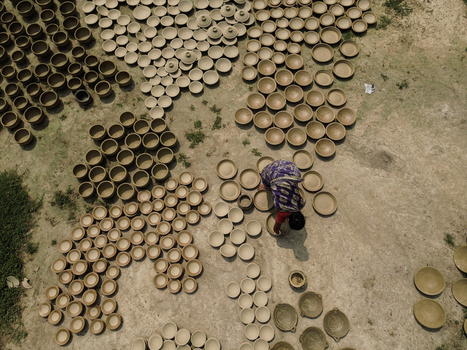 Joypurhat Rajshahi Division Bangladesh 28 September 2026 Aerial view of a woman arranging clay pots on the ground to dry under the sun in a traditional pottery workshop. Joypurhat Rajshahi Division Bangladesh 28 September 2026 Aerial view of a woman arranging clay pots on the ground to dry under the sun in a traditional pottery workshop.