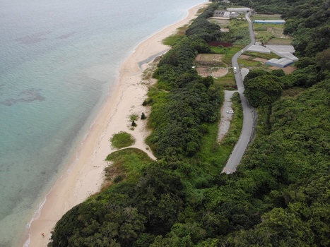 Aerial view of the coastline in the Hyakume area featuring a white sandy beach emerald green sea and lush greenery along the shore in Nanjo Okinawa Japan. Aerial view of the coastline in the Hyakume area featuring a white sandy beach emerald green sea and lush greenery along the shore in Nanjo Okinawa Japan.