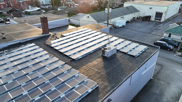Aerial view of solar panels installed on a flat commercial rooftop during sunset in Columbia Pennsylvania United States. Aerial view of solar panels installed on a flat commercial rooftop during sunset in Columbia Pennsylvania United States.