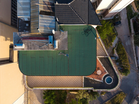 Aerial view of modern building rooftops with a green flat roof and a terrace featuring a small pool in Kruje Durres County Albania.
