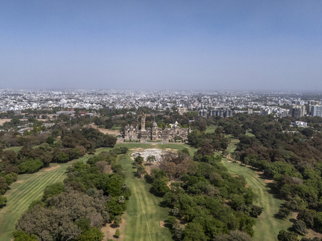 Vadodara India 14 March 2026 Aerial view of Laxmi Vilas Palace surrounded by lush green gardens golf course fairways and dense trees with the city skyline in the background. Vadodara India 14 March 2026 Aerial view of Laxmi Vilas Palace surrounded by lush green gardens golf course fairways and dense trees with the city skyline in the background.