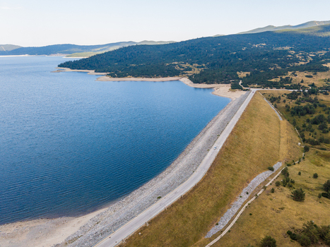 Aerial view of Belmeken Dam with its large blue reservoir stone faced embankment and surrounding forested hills in Pazardzhik Bulgaria. Aerial view of Belmeken Dam with its large blue reservoir stone faced embankment and surrounding forested hills in Pazardzhik Bulgaria.