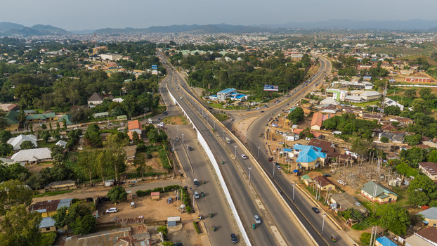Aerial view of a modern highway cutting through the lush landscape connecting the city with vibrant greens and distant hills Jos Plateau Nigeria.