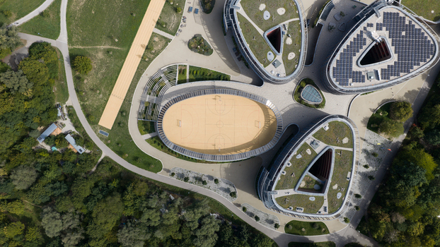 Durmersheim Germany 12 September 2026 Aerial view of Wilhelm Hausenstein Gymnasium featuring modern triangular buildings with green roofs solar panels and an oval sports court.