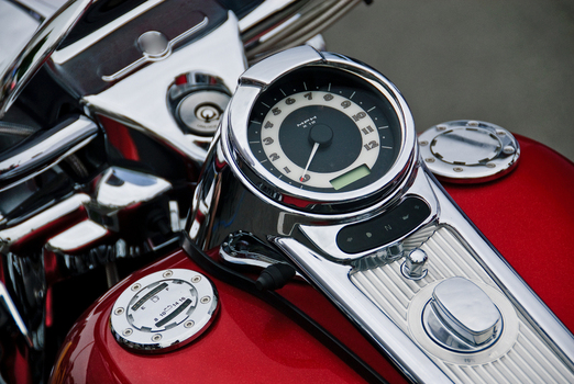 View of the chrome speedometer and fuel tank of a red motorcycle Canada. View of the chrome speedometer and fuel tank of a red motorcycle Canada.
