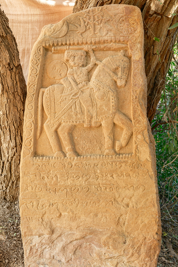 View of the ancient hero stone carving depicting a horseman with intricate inscriptions in Nagarparkar Sindh Pakistan.