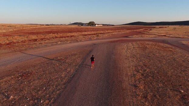 Aerial view of a runner on a dirt road in Spain.