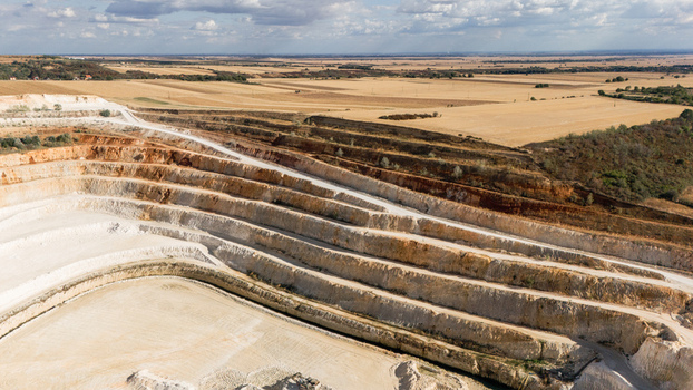 Aerial view of the Besenovo quarry showing terraced open pit mining levels exposed limestone layers and surrounding agricultural fields in Besenovo Vojvodina Serbia. Aerial view of the Besenovo quarry showing terraced open pit mining levels exposed limestone layers and surrounding agricultural fields in Besenovo Vojvodina Serbia.
