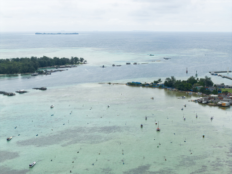Aerial view of the turquoise waters embracing the small islands and coastal houses a tranquil scene of Karimunjawa s beauty Karimunjawa Central Java Indonesia. Aerial view of the turquoise waters embracing the small islands and coastal houses a tranquil scene of Karimunjawa s beauty Karimunjawa Central Java Indonesia.
