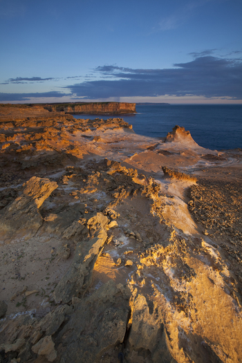 View of the rugged limestone cliffs and orange rock formations at Twelve Apostles Marine National Park under a twilight sky Australia. View of the rugged limestone cliffs and orange rock formations at Twelve Apostles Marine National Park under a twilight sky Australia.