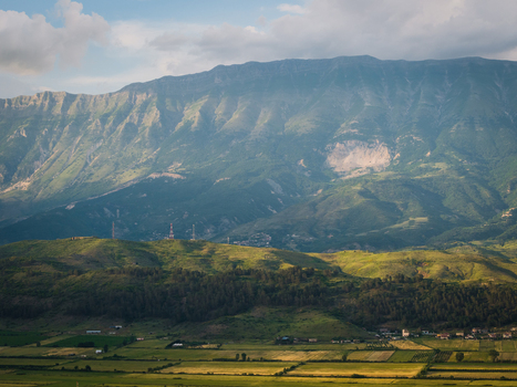 Aerial view of the majestic Mali i Gjere mountain range overlooking the Drino valley with lush green slopes and agricultural fields near Gjirokaster Gjirokaster County Albania. Aerial view of the majestic Mali i Gjere mountain range overlooking the Drino valley with lush green slopes and agricultural fields near Gjirokaster Gjirokaster County Albania.