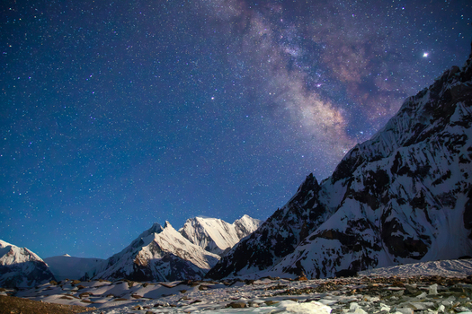 View of the Milky Way galaxy over the snow capped peaks of K2 Base Camp featuring rugged mountain terrain and a starry night sky in Gilgit Pakistan. View of the Milky Way galaxy over the snow capped peaks of K2 Base Camp featuring rugged mountain terrain and a starry night sky in Gilgit Pakistan.