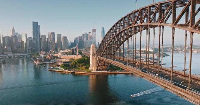 Aerial view of the Sydney Harbour Bridge spanning the harbour with the modern city skyline and skyscrapers in the background under clear morning light in Sydney New South Wales Australia. Aerial view of the Sydney Harbour Bridge spanning the harbour with the modern city skyline and skyscrapers in the background under clear morning light in Sydney New South Wales Australia.