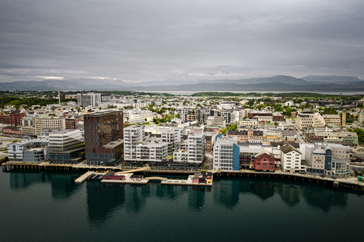 Aerial view of the coastal city of Bodo featuring modern architecture waterfront buildings and a harbor under a cloudy sky in Bodo Nordland Norway.