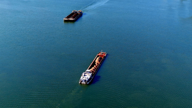 Aerial view of cargo barges transporting bulk materials along the Danube River in Smederevo Podunavlje District Serbia.