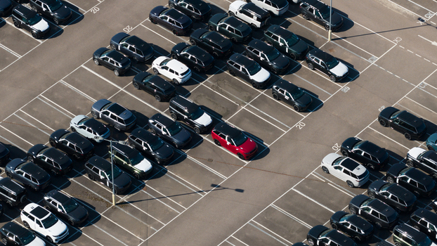 Aerial view of the JLR National Distribution Centre featuring rows of parked cars including a single red vehicle among many black and white ones in Baxterley England United Kingdom. Aerial view of the JLR National Distribution Centre featuring rows of parked cars including a single red vehicle among many black and white ones in Baxterley England United Kingdom.