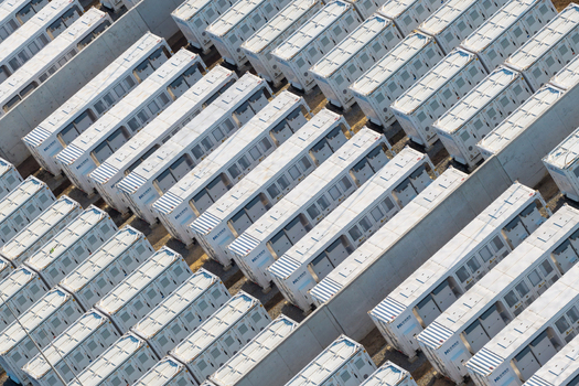 Poland 17 July 2026 Aerial view of a battery energy storage system featuring rows of white industrial storage containers arranged in an organized grid at an industrial site.