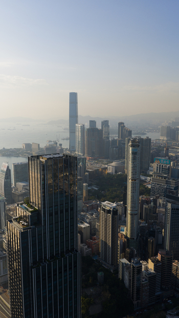 Aerial view of modern skyscrapers and the International Commerce Centre overlooking Victoria Harbour under a hazy sky in Hong Kong Hong Kong. Aerial view of modern skyscrapers and the International Commerce Centre overlooking Victoria Harbour under a hazy sky in Hong Kong Hong Kong.