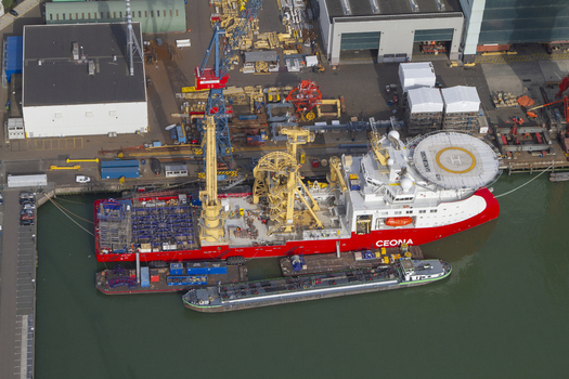 Aerial view of the Ceona Amazon offshore construction vessel docked at Rotterdam Harbour with industrial infrastructure and shipping containers in Rotterdam South Holland Netherlands. Aerial view of the Ceona Amazon offshore construction vessel docked at Rotterdam Harbour with industrial infrastructure and shipping containers in Rotterdam South Holland Netherlands.