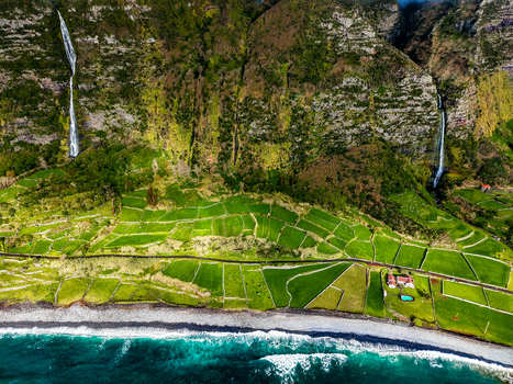 Aerial view of cascading waterfalls meet the terraced fields and rugged coastline contrasting with the turquoise waters of the Atlantic Faj&atilde; Grande Azores Portugal.