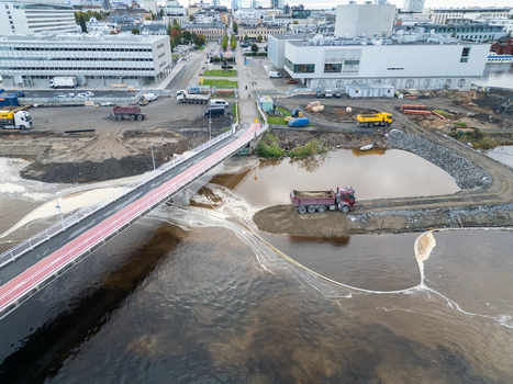 Oulu Finland 18 September 2026 Aerial view of construction site at waterfront with a bridge dump truck and modern buildings in the background. Oulu Finland 18 September 2026 Aerial view of construction site at waterfront with a bridge dump truck and modern buildings in the background.