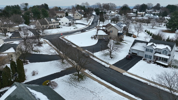 Aerial view of a quiet suburban neighborhood in Lititz covered in a fresh layer of winter snow with clear driveways and roads in Lititz Pennsylvania United States.
