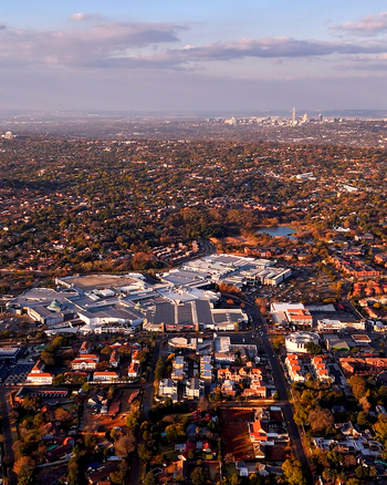 Aerial view of Cresta Shopping Centre surrounded by the densely developed Northcliff suburbs with the Johannesburg CBD skyline on the distant horizon in Johannesburg Gauteng South Africa. Aerial view of Cresta Shopping Centre surrounded by the densely developed Northcliff suburbs with the Johannesburg CBD skyline on the distant horizon in Johannesburg Gauteng South Africa.