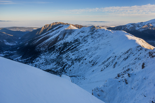 View of Ornak in Western Tatras with snow covered mountain ridges deep valleys and clear blue sky in Tatra County Lesser Poland Voivode Poland. View of Ornak in Western Tatras with snow covered mountain ridges deep valleys and clear blue sky in Tatra County Lesser Poland Voivode Poland.