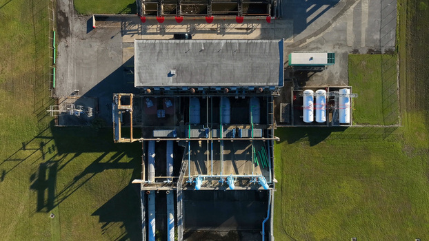 Aerial view of an industrial water treatment facility with storage tanks and piping infrastructure situated near the Lake Pontchartrain shoreline in Jefferson Parish Louisiana United States.