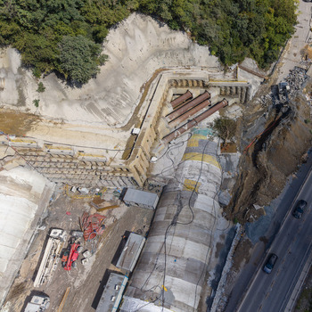 Aerial view of a tunnel construction site featuring concrete tunnel segments steel support pipes and heavy machinery near a hillside in Istanbul Istanbul Turkiye.
