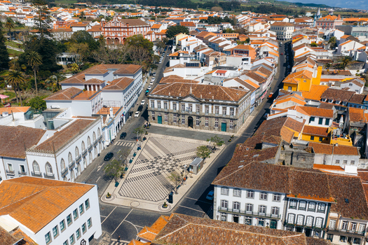Aerial view of Praca Velha with its patterned pavement and the historic Town Hall building surrounded by traditional houses in Angra do Heroismo Azores Portugal.