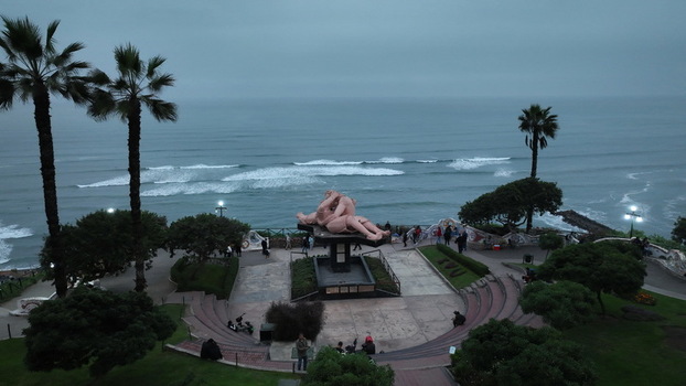 Aerial view of the El Beso sculpture in Love Park surrounded by palm trees and pathways overlooking the Pacific Ocean coastline in Miraflores Provincia de Lima Peru. Aerial view of the El Beso sculpture in Love Park surrounded by palm trees and pathways overlooking the Pacific Ocean coastline in Miraflores Provincia de Lima Peru.