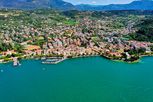 Aerial view of the town of Garda with its harbor colorful buildings and lush green hills on the shores of Lake Garda Garda Veneto Italy. Aerial view of the town of Garda with its harbor colorful buildings and lush green hills on the shores of Lake Garda Garda Veneto Italy.