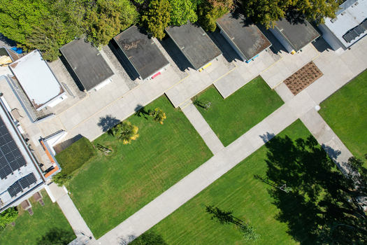 Aerial view of modern institutional buildings with flat roofs solar panels and concrete walkways crossing green lawns in Morges Vaud Switzerland. Aerial view of modern institutional buildings with flat roofs solar panels and concrete walkways crossing green lawns in Morges Vaud Switzerland.