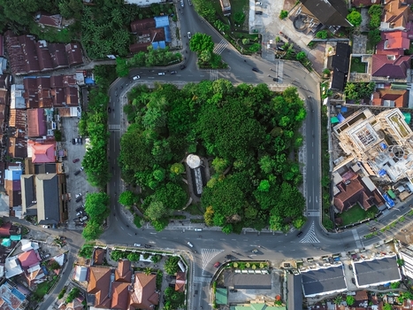 Aerial view of Taman Samarendah surrounded by lush green trees urban roads and residential rooftops in Samarinda East Kalimantan Indonesia. Aerial view of Taman Samarendah surrounded by lush green trees urban roads and residential rooftops in Samarinda East Kalimantan Indonesia.