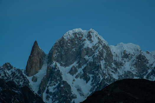 View of the Lady Finger peak with its sharp granite spire and snow covered slopes under a clear blue sky in Hunza Nagar Gilgit Pakistan. View of the Lady Finger peak with its sharp granite spire and snow covered slopes under a clear blue sky in Hunza Nagar Gilgit Pakistan.