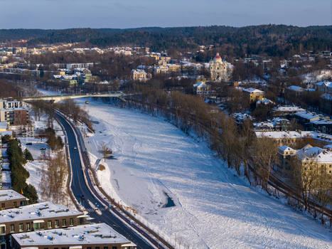 Aerial view of the frozen Neris River winding through the snow covered city landscape with the Church of St. Peter and St. Paul in the distance Vilnius County Lithuania.