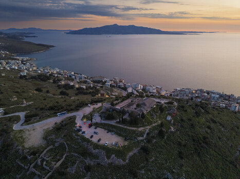 Aerial view of Lekuresi Castle overlooking the coastal city of Saranda and the Ionian Sea during golden hour in Saranda Vlore County Albania. Aerial view of Lekuresi Castle overlooking the coastal city of Saranda and the Ionian Sea during golden hour in Saranda Vlore County Albania.