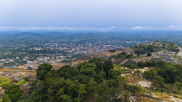 Aerial view of a landscape where rocky outcrops meet lush greenery with a distant town nestled under a vast sky Oyo Oyo Nigeria. Aerial view of a landscape where rocky outcrops meet lush greenery with a distant town nestled under a vast sky Oyo Oyo Nigeria.