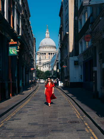 View of a vibrant red dress on a cobbled street leading to St. Paul s Cathedral s dome under a clear sky London England United Kingdom. View of a vibrant red dress on a cobbled street leading to St. Paul s Cathedral s dome under a clear sky London England United Kingdom.