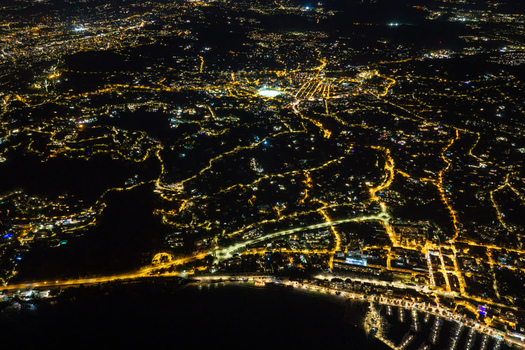 Aerial view of the illuminated city of Antibes at night showing glowing street lights urban infrastructure and the harbor along the coastline in Antibes Provence Alpes Cote d Azur France. Aerial view of the illuminated city of Antibes at night showing glowing street lights urban infrastructure and the harbor along the coastline in Antibes Provence Alpes Cote d Azur France.