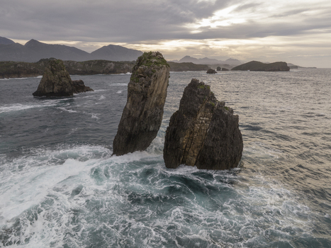 Aerial view of the dramatic rock formations rising from the turbulent sea at the coast of Nueva Asturias Spain.