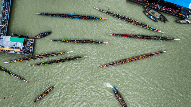 Baghabari Rajshahi Division Bangladesh 20 August 2022 Aerial view of a traditional boat race with many long narrow boats filled with rowers navigating the river.