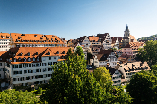 Aerial view of the historic old town with traditional half timbered houses red tiled roofs and the Stiftskirche tower under a clear blue sky in Tubingen Baden Wurttemberg Germany. Aerial view of the historic old town with traditional half timbered houses red tiled roofs and the Stiftskirche tower under a clear blue sky in Tubingen Baden Wurttemberg Germany.
