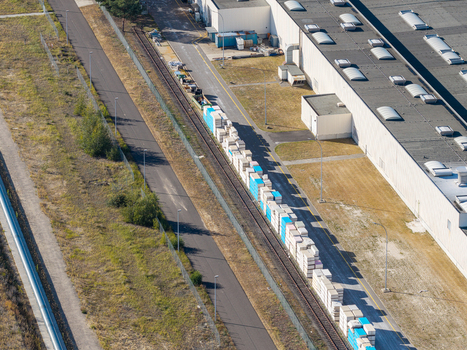 Aerial view of a freight train loaded with building materials on tracks adjacent to a large industrial warehouse facility in Peitz Brandenburg Germany. Aerial view of a freight train loaded with building materials on tracks adjacent to a large industrial warehouse facility in Peitz Brandenburg Germany.