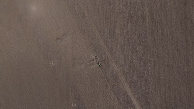 Aerial view of a tractor plowing a vast brown field Portugal. Aerial view of a tractor plowing a vast brown field Portugal.