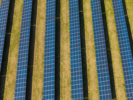 Aerial view of Lisburn Solar Farm with rows of photovoltaic panels arranged in neat lines across a grassy field in Lisburn Northern Ireland United Kingdom. Aerial view of Lisburn Solar Farm with rows of photovoltaic panels arranged in neat lines across a grassy field in Lisburn Northern Ireland United Kingdom.