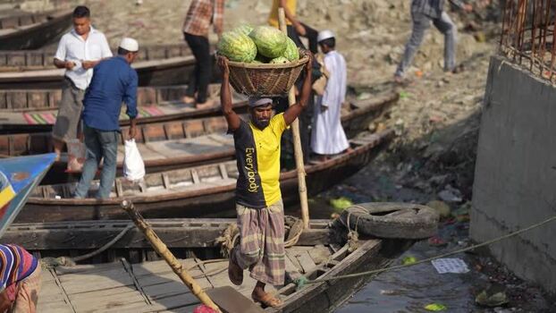 View of a worker carrying watermelons at Sadarghat Bangladesh.