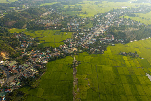 Aerial view of the town of Lien Son Lak nestled beside the expansive Lak Lake surrounded by lush green rice paddies and rolling hills in Lien Son Lak Dak Lak Vietnam. Aerial view of the town of Lien Son Lak nestled beside the expansive Lak Lake surrounded by lush green rice paddies and rolling hills in Lien Son Lak Dak Lak Vietnam.
