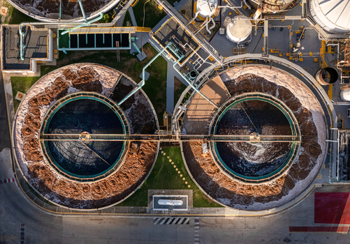 Aerial view of the beer industrial complex featuring large circular wastewater treatment tanks with bubbling aeration systems and industrial piping in Santo Domingo Dominican Republic. Aerial view of the beer industrial complex featuring large circular wastewater treatment tanks with bubbling aeration systems and industrial piping in Santo Domingo Dominican Republic.